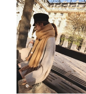 Thick camel mohair scarf with oversized tassels shown in an outdoor autumn fashion setting