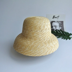 Detail of cloche straw sun hat showing natural fine woven texture and vintage brim style