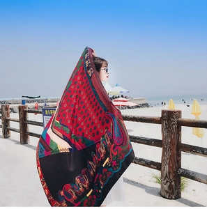 Detail of red and black paisley print chiffon shawl fluttering in sea breeze