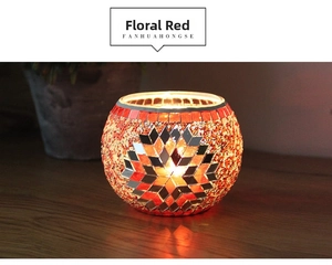 Macro shot of handmade mosaic glass candle holder with glowing red floral patterns