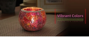 Close-up of handmade mosaic glass candle holder with warm yellow light and floral pattern
