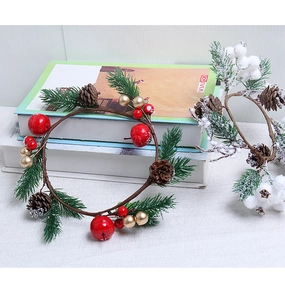 Detail of Christmas wreath with pine needles, cones, berries and golden ball ornaments