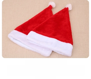 Detail showing two plush red and white Christmas hats with soft pom poms and wide fur trim