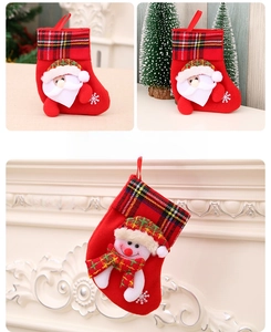 Detail of red Christmas stocking with snowman doll, tartan cuff and snowflake embroidery