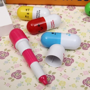 Macro shot of colorful pill-shaped ballpoint pens with cute faces and vitamin prints