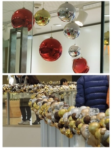 Close-up of metallic silver and gold Christmas ornaments hanging on indoor railings