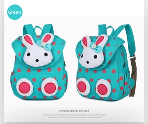 Detail view of the green polka dot kids backpack with 3D plush bunny and side pocket