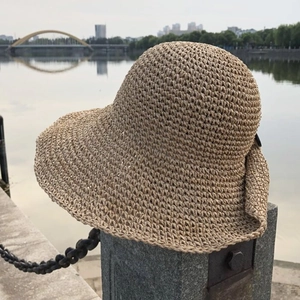 Close-up of hand-woven straw sun hat texture with elegant wide wavy brim for sun protection
