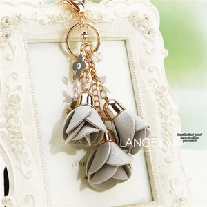 Detail of leather flower charms with rose gold metal clasp and rhinestone clover pendant