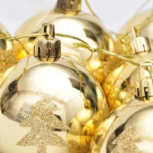 Detail of golden Christmas ball ornaments with glossy finish and glitter cedar patterns