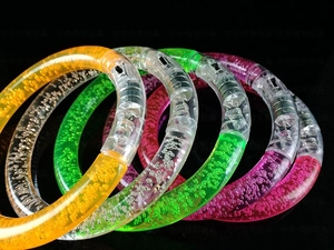 Macro detail of LED glowing acrylic bubble bracelets in four bright colors for party