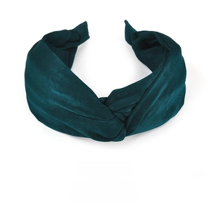 Detail of dark green wide fabric headband with a stylish cross knot texture