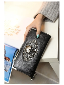 Macro view of black skull punk wallet with embossed silver metal carving and corner protection