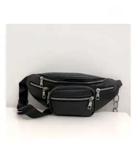 Detail of black faux leather waist bag featuring multiple silver zippers and decorative chain