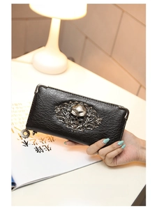 Detail of black punk wallet with silver skull emblem and vintage metal corners