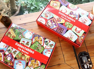 Detail of red Christmas tin boxes with festive Santa and snowman illustrations