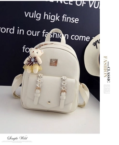 Detailansicht des cremefarbenen Rucksacks mit Blumendekor und einem Teddybären-Anhänger