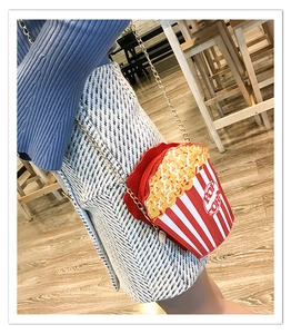 Detail shot of creative popcorn bucket bag with red stripes and gold chain strap