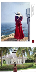 Detail of red bohemian summer dress paired with straw hat on a coastal beach scene