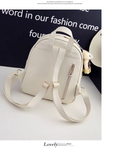 Detailansicht weißer PU-Leder Mini-Rucksack mit goldener Hardware und Bären-Anhänger