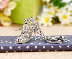 Detailed close-up of a silver high heel keychain featuring hollow mesh and metal clasp