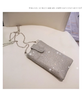 Close-up of luxury silver crossbody phone bag with full rhinestone crystals and chain
