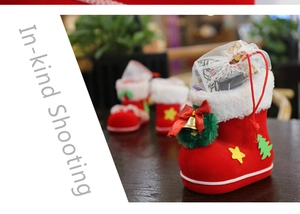 Detail of red felt Christmas boot gift bag with festive patches and mesh drawstring closure