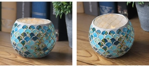 Detailed view of round blue and gold mosaic glass candle holder with scale pattern texture