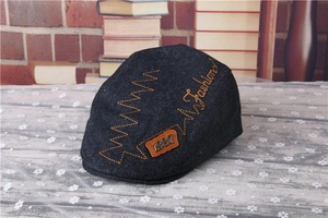 Close-up of navy blue denim children's cap with orange fashion embroidery and vintage label