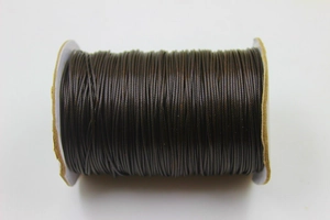Close-up of deep brown round waxed cord spool for DIY handmade jewelry weaving