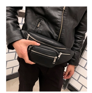 Close-up of black leather waist bag with multiple zippers and detailed grain texture