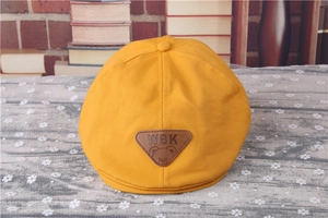 Detail of baby yellow striped beret with cartoon bear leather patch and cotton fabric