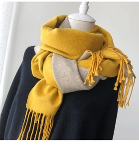 Detail of soft cashmere-like scarf with yellow and grey contrast and fringe trim