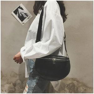 Minimalist black crescent crossbody bag styled with white shirt and denim for casual look