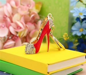 Detail shot of red enamel high heel keychain with rhinestones on colorful books