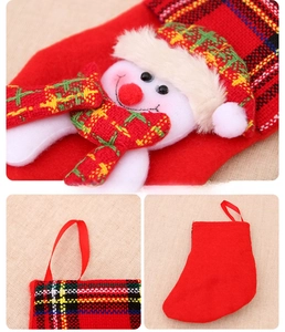 Detail of red Christmas stocking with snowman decor and plaid cuff for holiday hanging