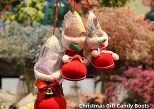 Close-up of red flocked Christmas candy boots with white mesh and holly decorations