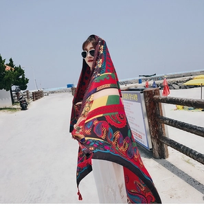 Close-up of lightweight red bohemian print beach shawl with decorative fringe details