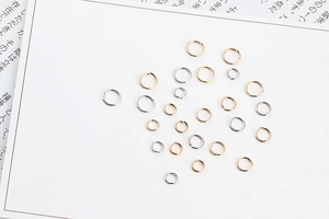 Macro detail of multi-size gold and silver jump rings for DIY jewelry making