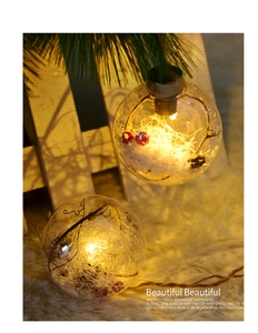 Close-up of lighted 8cm clear Christmas ball with LED warm glow and festive snow scene inside