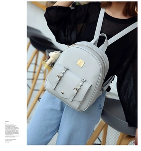 Detail eines hellgrauen PU-Lederrucksacks mit 3D-Blumen und süßem Bären-Anhänger