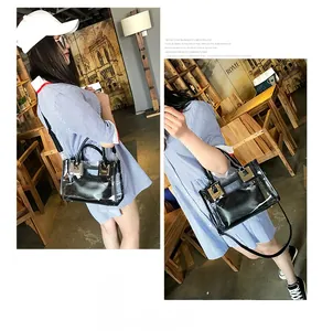 Detail view of transparent PVC tote bag with black leather inner pouch and gold buckle