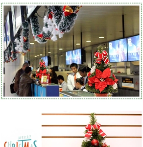 Dettaglio mini albero di Natale da tavolo con stelle di Natale rosse e fiocchi a righe