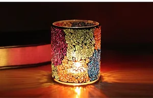 Close-up of a mosaic glass candle holder with warm colorful light reflection and texture