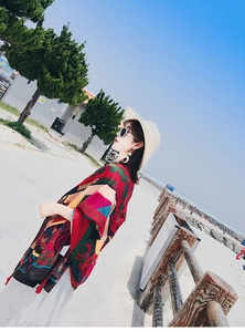 Close-up of vibrant ethnic print shawl with red tassels on lightweight fabric