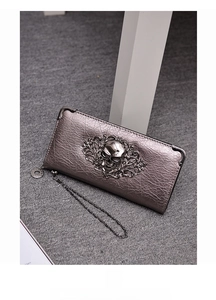 Close-up of gothic silver skull embossing on pebble leather long wallet with chain