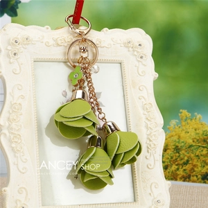 Detail of green leather flower charm with rose gold chain and clover crystal pendant