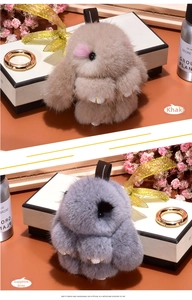 Detail of plush bunny charms in khaki and gem grey colors with premium metal keyrings