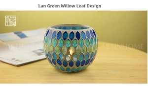 Detail of leaf-shaped blue and green mosaic glass tea light holder with candle glowing inside