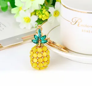 Close-up of golden pineapple keychain with yellow cat-eye stones and green crystals